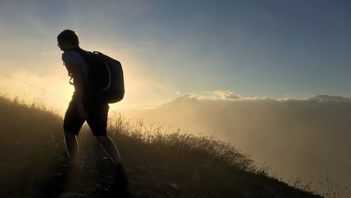 Silhouette eines Wanderers, der Bergauf geht